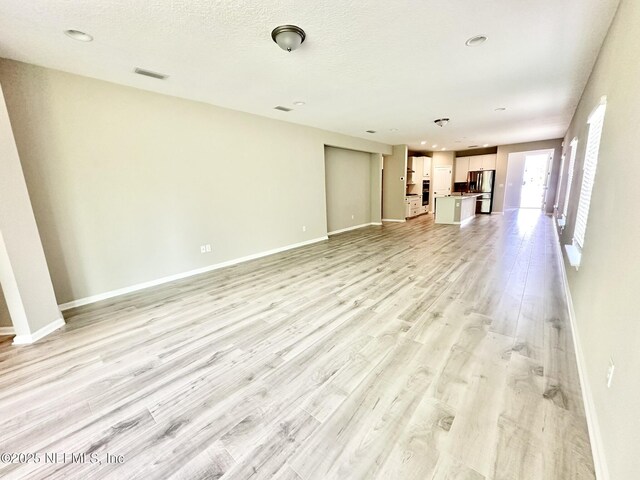 356 Bermudez Way, Saint Augustine, FL 32095 - unfurnished living room featuring light wood-type flooring and baseboards