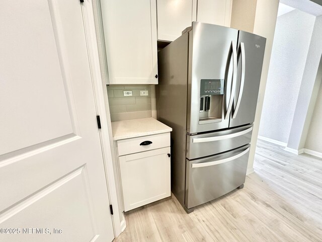 356 Bermudez Way, Saint Augustine, FL 32095 - kitchen with stainless steel fridge, light wood finished floors, backsplash, and white cabinetry