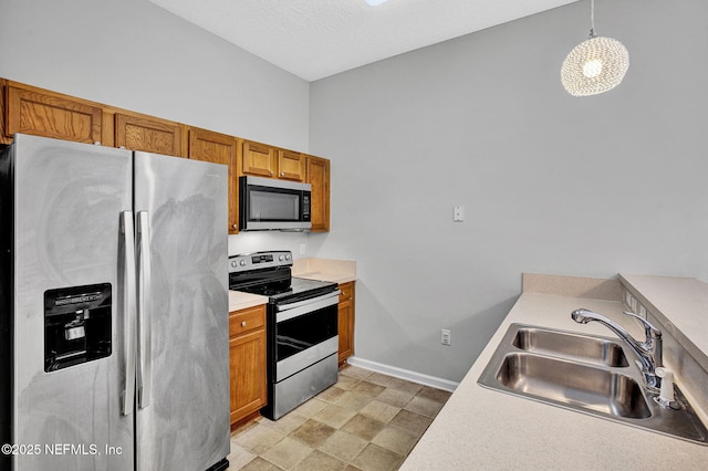 7920 Merrill Rd Unit 403, Jacksonville, FL 32277 - kitchen featuring stainless steel appliances, brown cabinets, light countertops, decorative light fixtures, and stone finish flooring