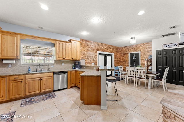 34100 Old Baldwin Rd, Callahan, FL 32011 - kitchen featuring dishwasher, a peninsula, a kitchen bar, a textured ceiling, and backsplash