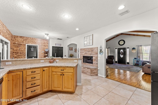 34100 Old Baldwin Rd, Callahan, FL 32011 - kitchen featuring open floor plan, a fireplace, a textured ceiling, and arched walkways