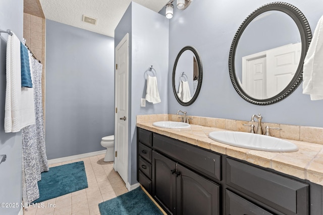 34100 Old Baldwin Rd, Callahan, FL 32011 - bathroom with double vanity, tile patterned flooring, a shower with curtain, and a textured ceiling