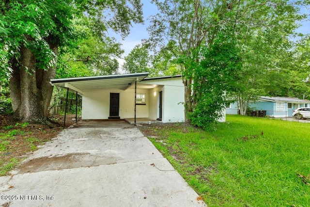 9340 Norfolk Blvd, Jacksonville, FL 32208 - mid-century modern home featuring concrete driveway, a carport, and a front lawn