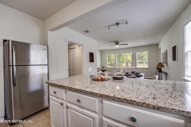 3516 Myra St, Jacksonville, FL 32205 - kitchen with freestanding refrigerator, a ceiling fan, light stone counters, a textured ceiling, and light tile patterned flooring