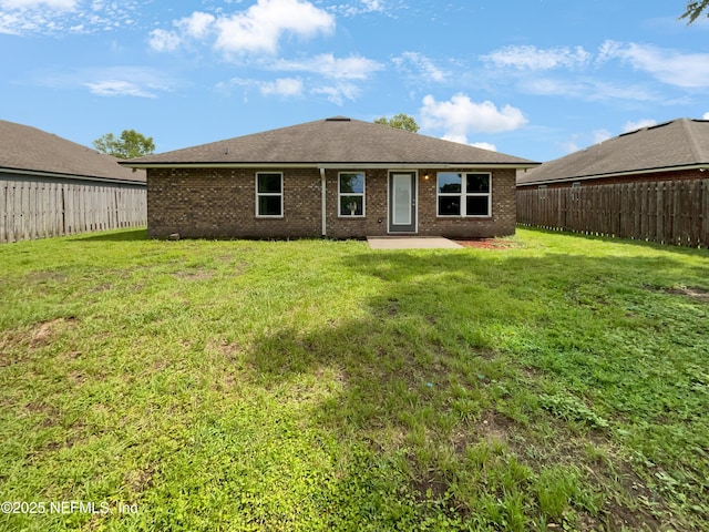 6191 Daylilly Rd, Macclenny, FL 32063 - rear view of house with a fenced backyard, brick siding, a patio, and roof with shingles