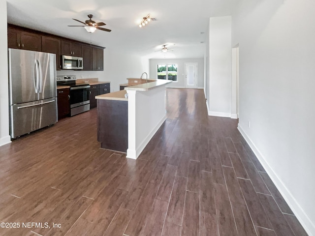 6191 Daylilly Rd, Macclenny, FL 32063 - kitchen with stainless steel appliances, a ceiling fan, dark wood-style floors, dark brown cabinets, and light countertops