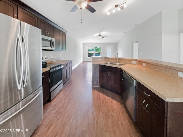 6191 Daylilly Rd, Macclenny, FL 32063 - kitchen with appliances with stainless steel finishes, a ceiling fan, vaulted ceiling, dark brown cabinets, and light wood-style floors