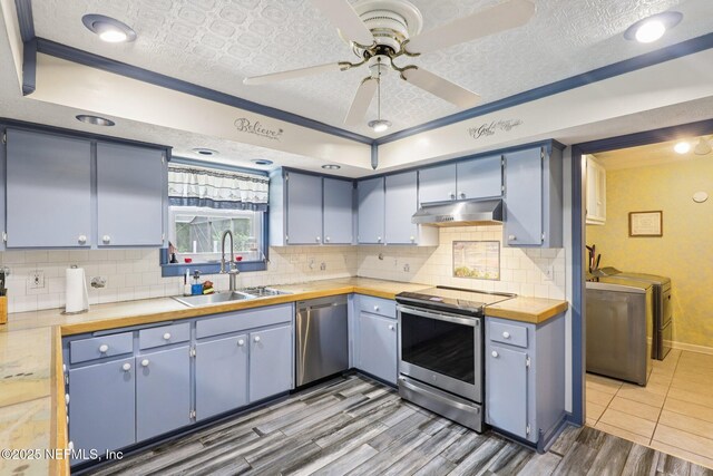 1071 Foxmeadow Trl, Middleburg, FL 32068 - kitchen featuring stainless steel appliances, under cabinet range hood, wood finished floors, a ceiling fan, and independent washer and dryer