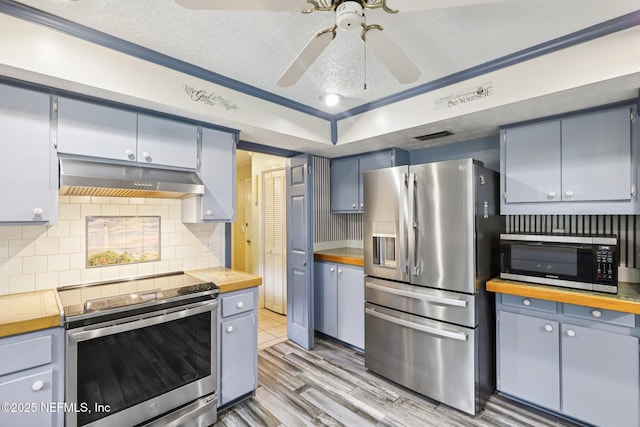 1071 Foxmeadow Trl, Middleburg, FL 32068 - kitchen featuring stainless steel appliances, under cabinet range hood, wooden counters, and light wood finished floors