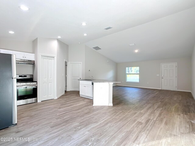 9473 N Athenia Dr, Citrus Springs, FL 34434 - kitchen with appliances with stainless steel finishes, vaulted ceiling, open floor plan, white cabinets, and under cabinet range hood