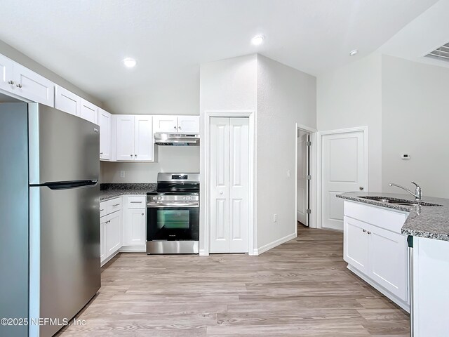 9473 N Athenia Dr, Citrus Springs, FL 34434 - kitchen with stainless steel appliances, under cabinet range hood, dark stone countertops, white cabinets, and recessed lighting