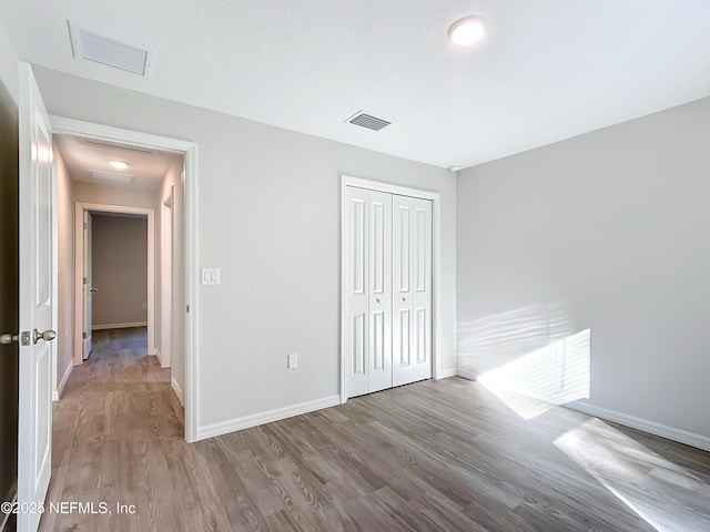 9473 N Athenia Dr, Citrus Springs, FL 34434 - unfurnished bedroom featuring wood finished floors, a closet, and attic access