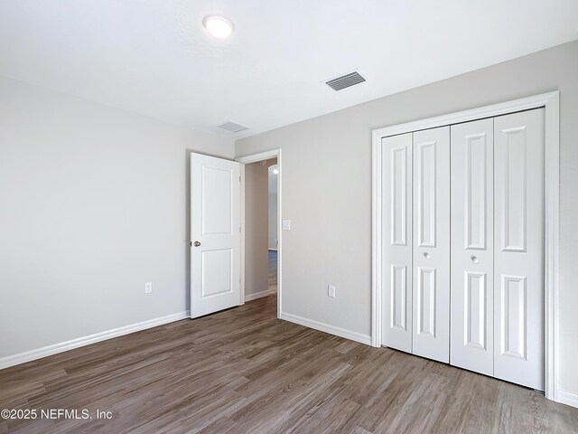 9473 N Athenia Dr, Citrus Springs, FL 34434 - unfurnished bedroom with wood finished floors and a closet