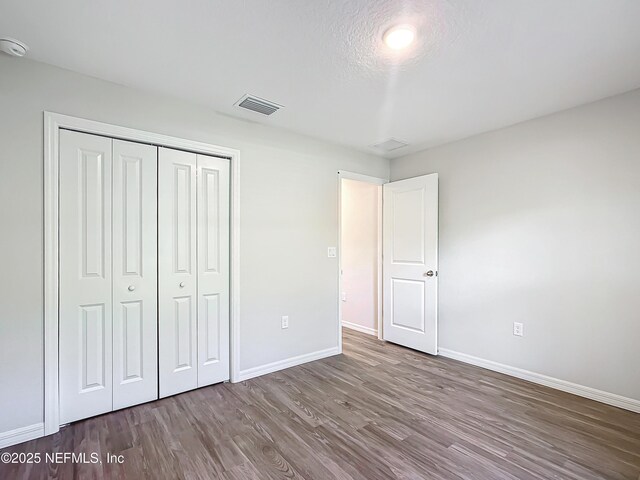 9473 N Athenia Dr, Citrus Springs, FL 34434 - unfurnished bedroom with wood finished floors and a closet
