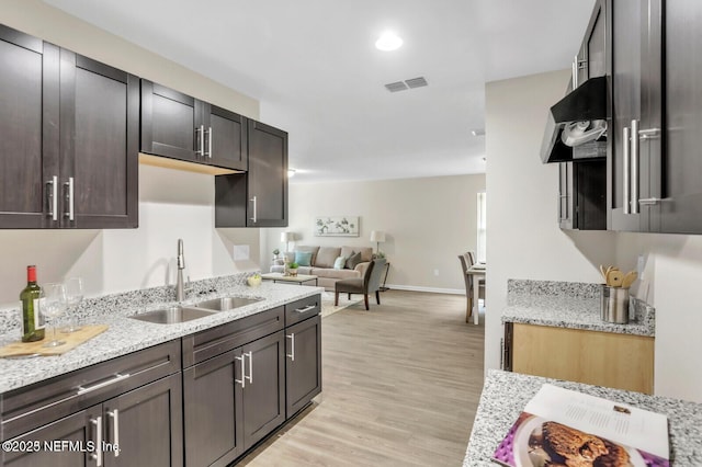 4730 Ridgewood Ave, Jacksonville, FL 32207 - kitchen featuring light wood finished floors, extractor fan, light stone counters, and dark brown cabinetry