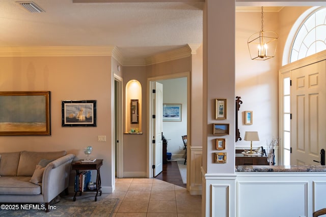 13464 Ellsworth Ln, Jacksonville, FL 32225 - foyer featuring crown molding, light tile patterned flooring, and a chandelier