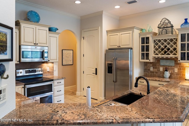 13464 Ellsworth Ln, Jacksonville, FL 32225 - kitchen featuring stainless steel appliances, dark stone counters, arched walkways, tasteful backsplash, and recessed lighting