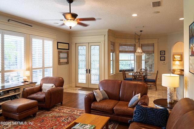 13464 Ellsworth Ln, Jacksonville, FL 32225 - living room featuring french doors, a ceiling fan, ornamental molding, a textured ceiling, and wood finished floors