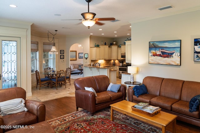 13464 Ellsworth Ln, Jacksonville, FL 32225 - living room featuring ceiling fan, arched walkways, ornamental molding, recessed lighting, and light wood-style flooring