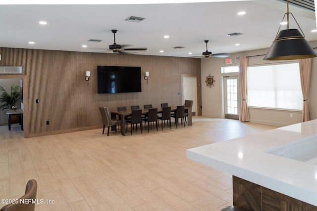 13464 Ellsworth Ln, Jacksonville, FL 32225 - dining space with a ceiling fan, an accent wall, recessed lighting, and light wood-style flooring