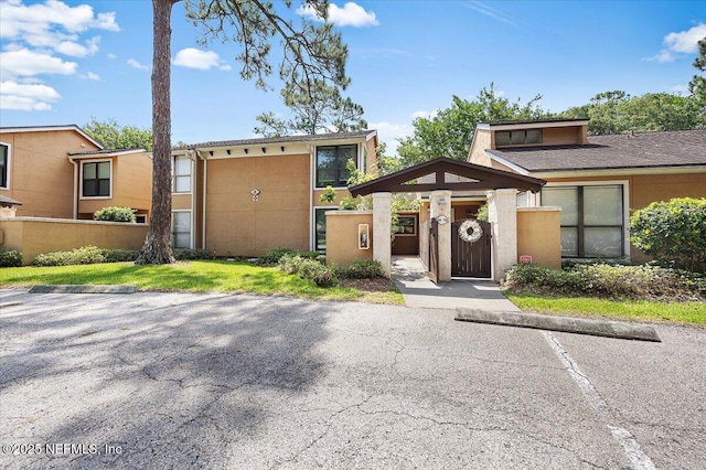 730 Tidewater Ct, Ponte Vedra Beach, FL 32082 - view of front of home featuring uncovered parking, stucco siding, and a gate