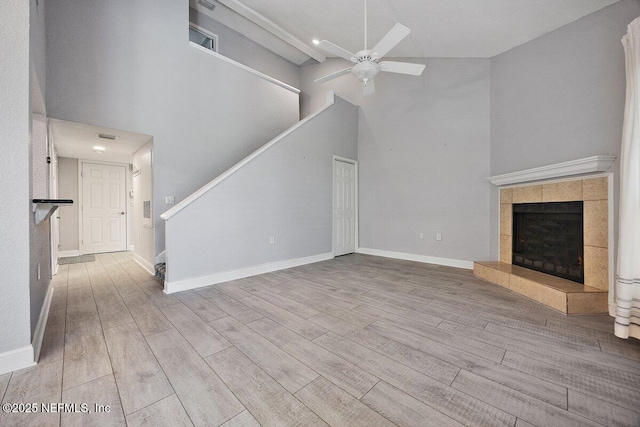 730 Tidewater Ct, Ponte Vedra Beach, FL 32082 - unfurnished living room with ceiling fan, stairs, wood finished floors, a high ceiling, and a tile fireplace