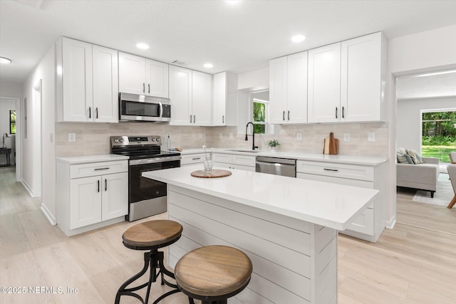 2453 Jetty Ct, Jacksonville, FL 32233 - kitchen with appliances with stainless steel finishes, light wood-style flooring, light countertops, decorative backsplash, and recessed lighting