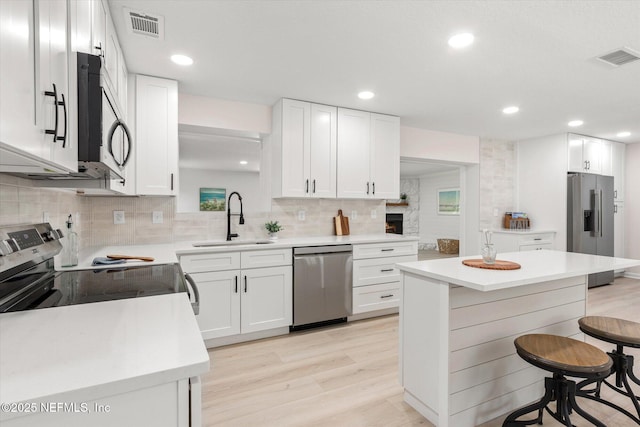 2453 Jetty Ct, Jacksonville, FL 32233 - kitchen featuring stainless steel appliances, a breakfast bar area, light wood-type flooring, backsplash, and light countertops