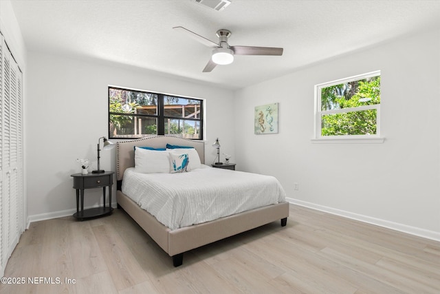 2453 Jetty Ct, Jacksonville, FL 32233 - bedroom with light wood-style floors, multiple windows, a ceiling fan, and a closet