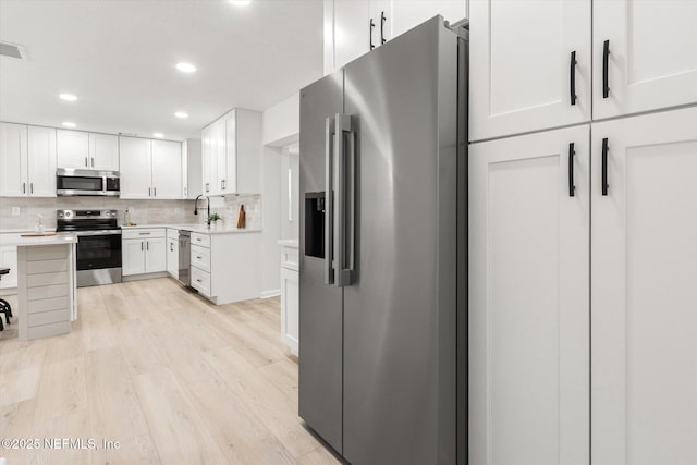 2453 Jetty Ct, Jacksonville, FL 32233 - kitchen with stainless steel appliances, light wood-style flooring, decorative backsplash, recessed lighting, and light countertops