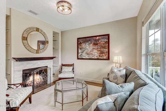 644 Sun Down Cir, Saint Augustine, FL 32080 - living room featuring wood finished floors, a stone fireplace, and built in features