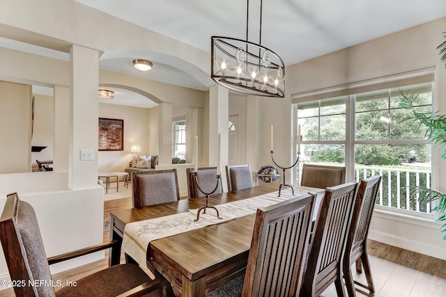644 Sun Down Cir, Saint Augustine, FL 32080 - dining room with arched walkways, light wood-style floors, and a chandelier