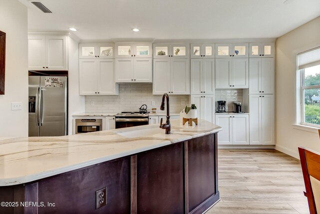 644 Sun Down Cir, Saint Augustine, FL 32080 - kitchen with stainless steel appliances, decorative backsplash, light wood-style floors, light stone counters, and recessed lighting
