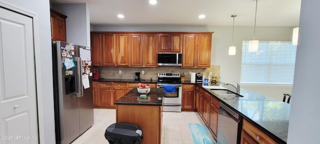 308 Winding Oak Way, Saint Augustine, FL 32084 - kitchen with stainless steel appliances, decorative backsplash, brown cabinetry, dark stone countertops, and decorative light fixtures