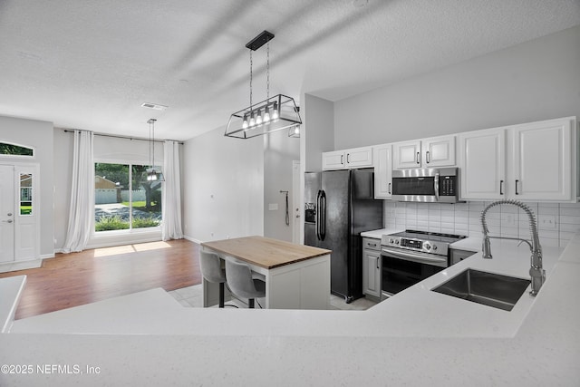 429 N Bridgestone Ave, Saint Johns, FL 32259 - kitchen with stainless steel appliances, wood counters, backsplash, a textured ceiling, and hanging light fixtures