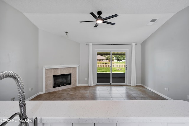 429 N Bridgestone Ave, Saint Johns, FL 32259 - unfurnished living room with a fireplace, a ceiling fan, vaulted ceiling, and tile patterned floors