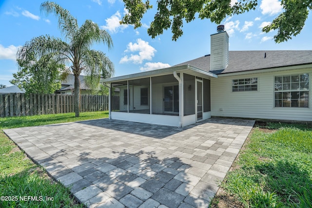 429 N Bridgestone Ave, Saint Johns, FL 32259 - rear view of house with a sunroom, a chimney, a patio area, and roof with shingles