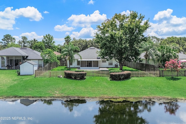 429 N Bridgestone Ave, Saint Johns, FL 32259 - rear view of property featuring a storage shed, a fenced backyard, a water view, and a sunroom
