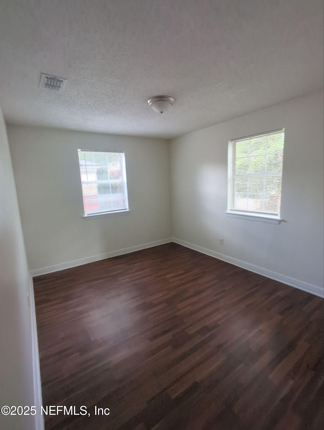 3136 Post St, Jacksonville, FL 32205 - empty room with plenty of natural light, dark wood-style flooring, and a textured ceiling