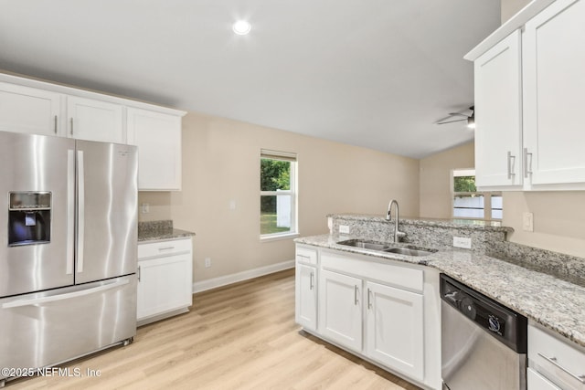 78262 Saddle Rock Rd, Yulee, FL 32097 - kitchen with appliances with stainless steel finishes, a peninsula, white cabinets, and vaulted ceiling
