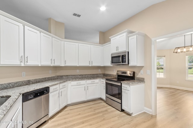 78262 Saddle Rock Rd, Yulee, FL 32097 - kitchen featuring stainless steel appliances, light wood-type flooring, white cabinetry, and light stone countertops