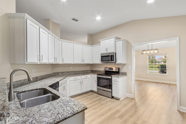 78262 Saddle Rock Rd, Yulee, FL 32097 - kitchen with appliances with stainless steel finishes, white cabinets, light stone countertops, light wood-type flooring, and recessed lighting