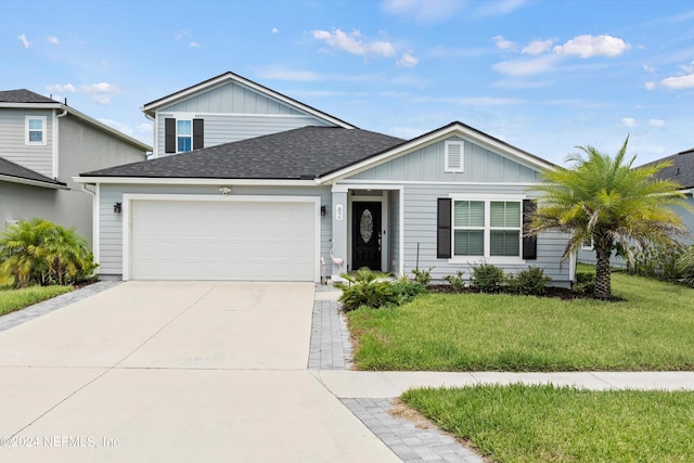82 Birchfield Ln, Saint Augustine, FL 32092 - view of front facade featuring an attached garage, a shingled roof, a front lawn, concrete driveway, and board and batten siding