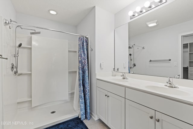 82 Birchfield Ln, Saint Augustine, FL 32092 - bathroom with a shower stall, double vanity, tile patterned floors, and a textured ceiling
