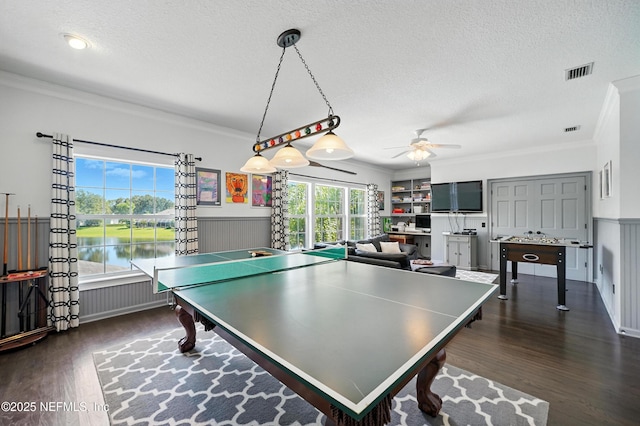 8483 Stables Rd, Jacksonville, FL 32256 - rec room with a ceiling fan, a textured ceiling, crown molding, and dark wood-style flooring