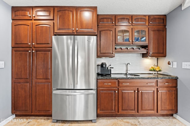 1786 Selva Marina Dr, Atlantic Beach, FL 32233 - kitchen featuring freestanding refrigerator, dark stone counters, glass insert cabinets, and tasteful backsplash