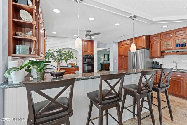 1786 Selva Marina Dr, Atlantic Beach, FL 32233 - kitchen featuring freestanding refrigerator, tasteful backsplash, brown cabinetry, glass insert cabinets, and recessed lighting