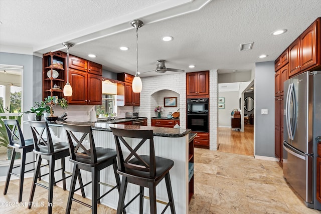 1786 Selva Marina Dr, Atlantic Beach, FL 32233 - kitchen with appliances with stainless steel finishes, a peninsula, ceiling fan, dark countertops, and a breakfast bar area