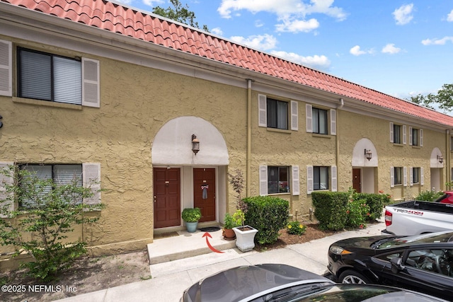 5811 Atlantic Blvd Unit 25, Jacksonville, FL 32207 - view of front of property featuring uncovered parking, stucco siding, and a tiled roof