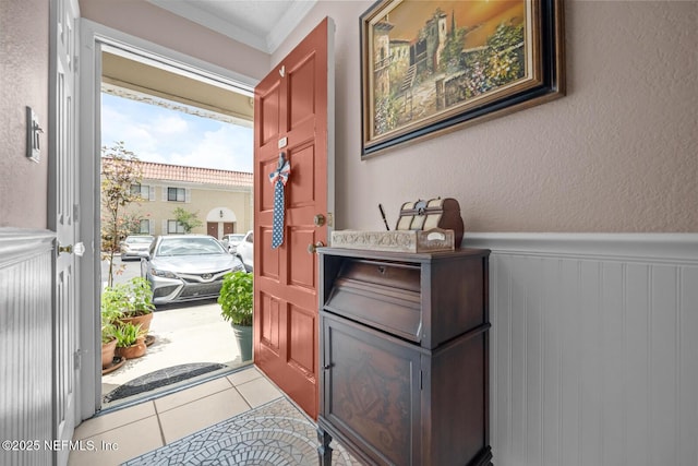 5811 Atlantic Blvd Unit 25, Jacksonville, FL 32207 - foyer with crown molding, a wainscoted wall, tile patterned flooring, and a textured wall